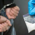Terrifying New Street Sedative Overruns Philly Person handcuffed, police holding bag of white substance.