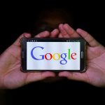Internet Providers Face A Disruption They Can’t Control Hands holding smartphone displaying Google logo.