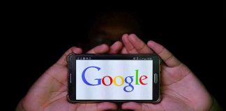 Hands holding smartphone displaying Google logo.