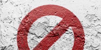A red prohibition symbol on a textured white wall