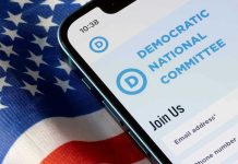 Democrats Lost The Room With One Opening Moment Phone displaying Democratic National Committee website over flag.