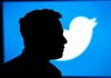 Silhouette of person against blue Twitter logo background.