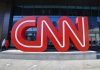 Large red CNN sign outside building entrance.